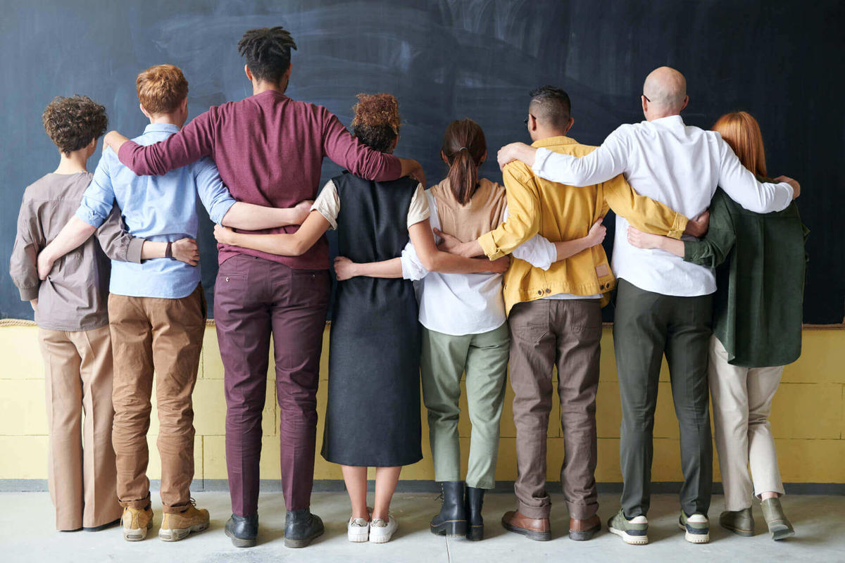 Diverse people in row putting arms around each other