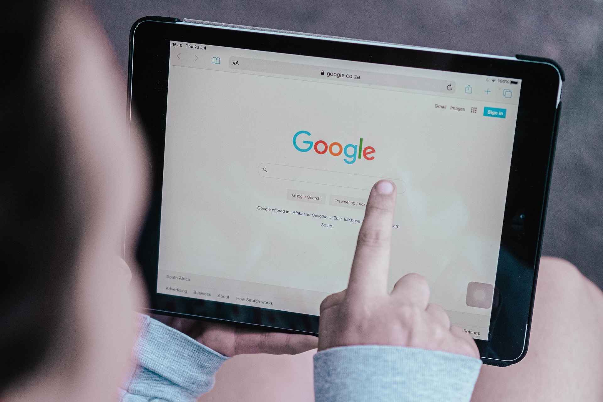 junge person startet google suche auf tablet in ihrer hand
